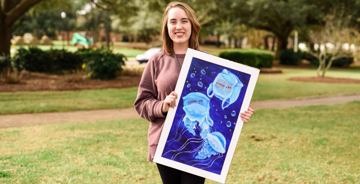格雷斯·理查森, 来自胡佛的十大彩票网投平台大一新生, 她手里拿着一幅画，这是她“水瓶座计划”活动的一部分. 由于她的工作，她获得了女童子军金奖. 